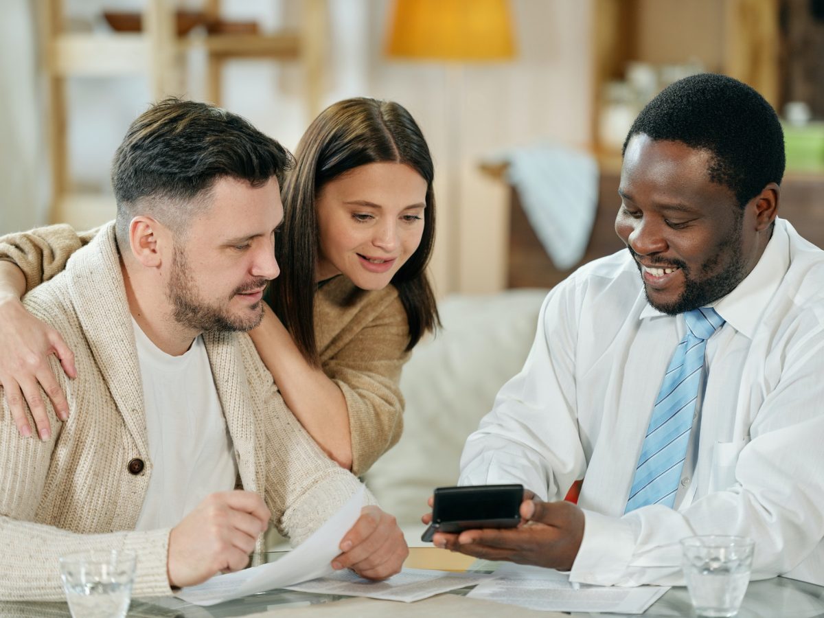 Content man advising young couple on home loan