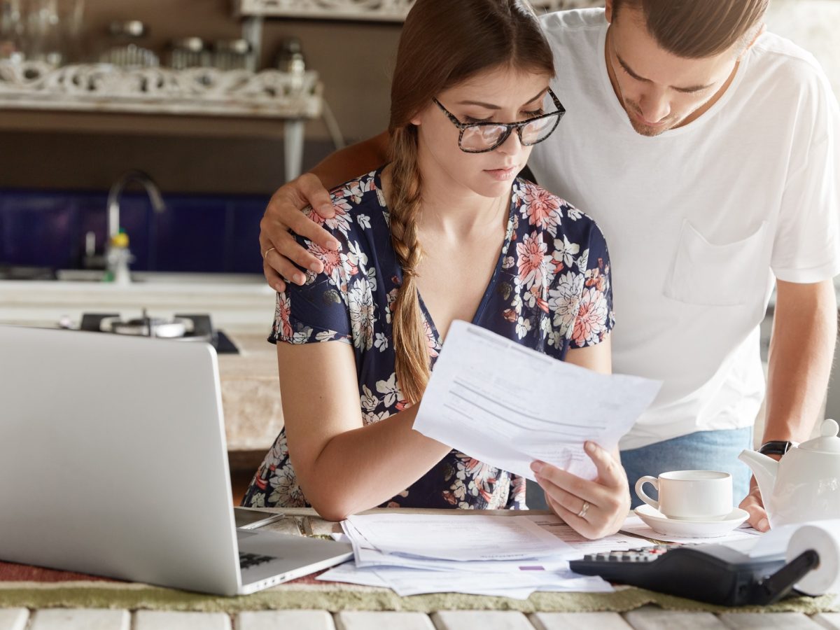 Cropped view of attractive young female and man study bank papers attentively, going to take loan fo